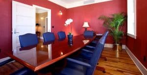 A conference room with eight blue leather chairs and a shiny conference table